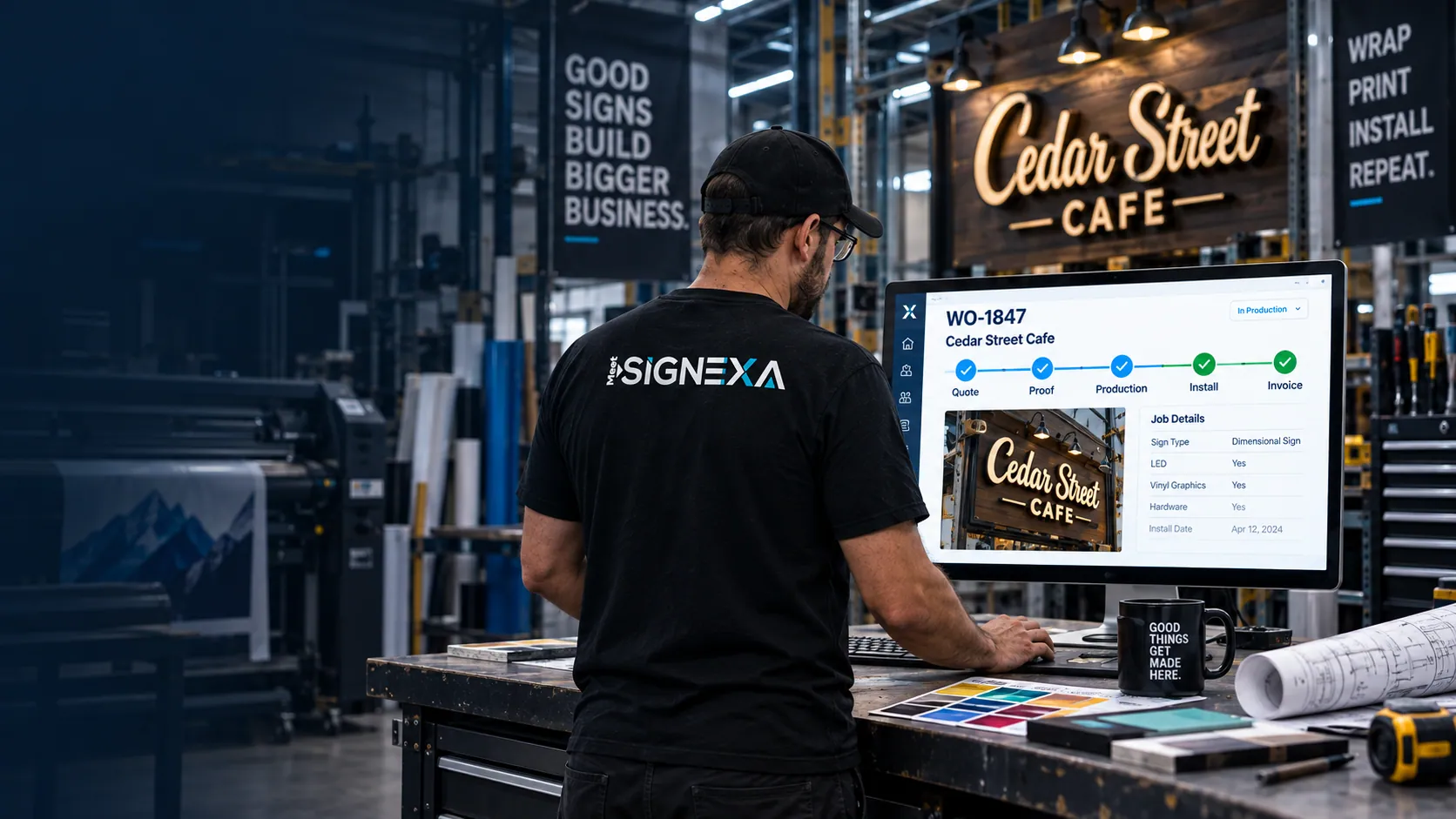 Illustrative sign shop operator reviewing a Cedar Street Cafe work order beside a finished dimensional sign.